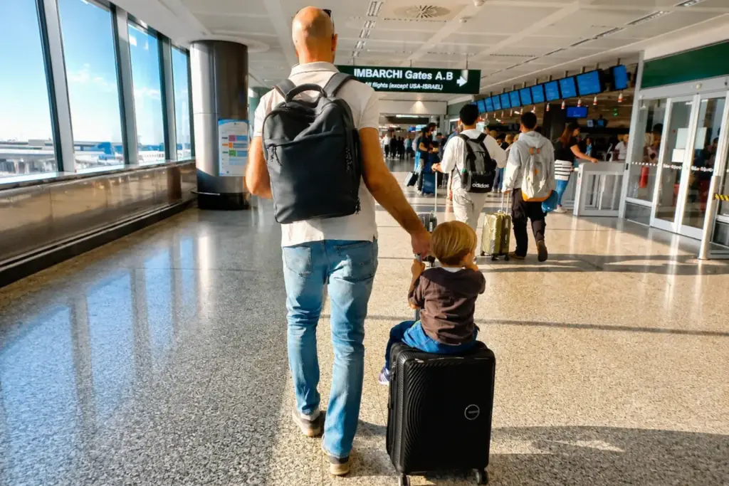 Bambino con il papà in aeroporto prima dell'imbarco per un viaggio in aereo con bambini
